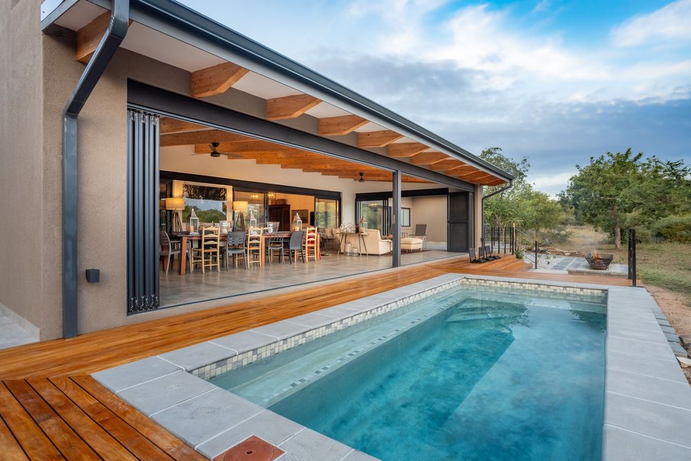 Luxury villa exterior at sunset with pool and patio area