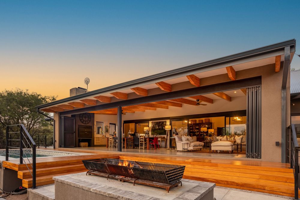 Luxury villa exterior at sunset with pool and patio area