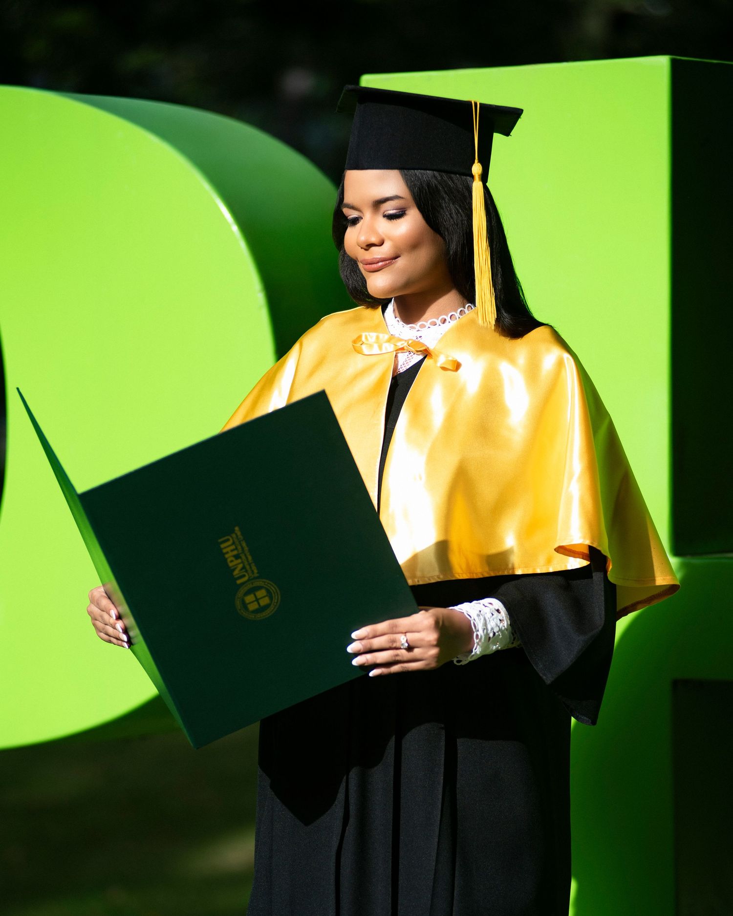 Sesión fotográfica de graduación UNPHU con toga y birrete, fotos profesionales y creativas en estudio o exteriores en República Dominicana.
