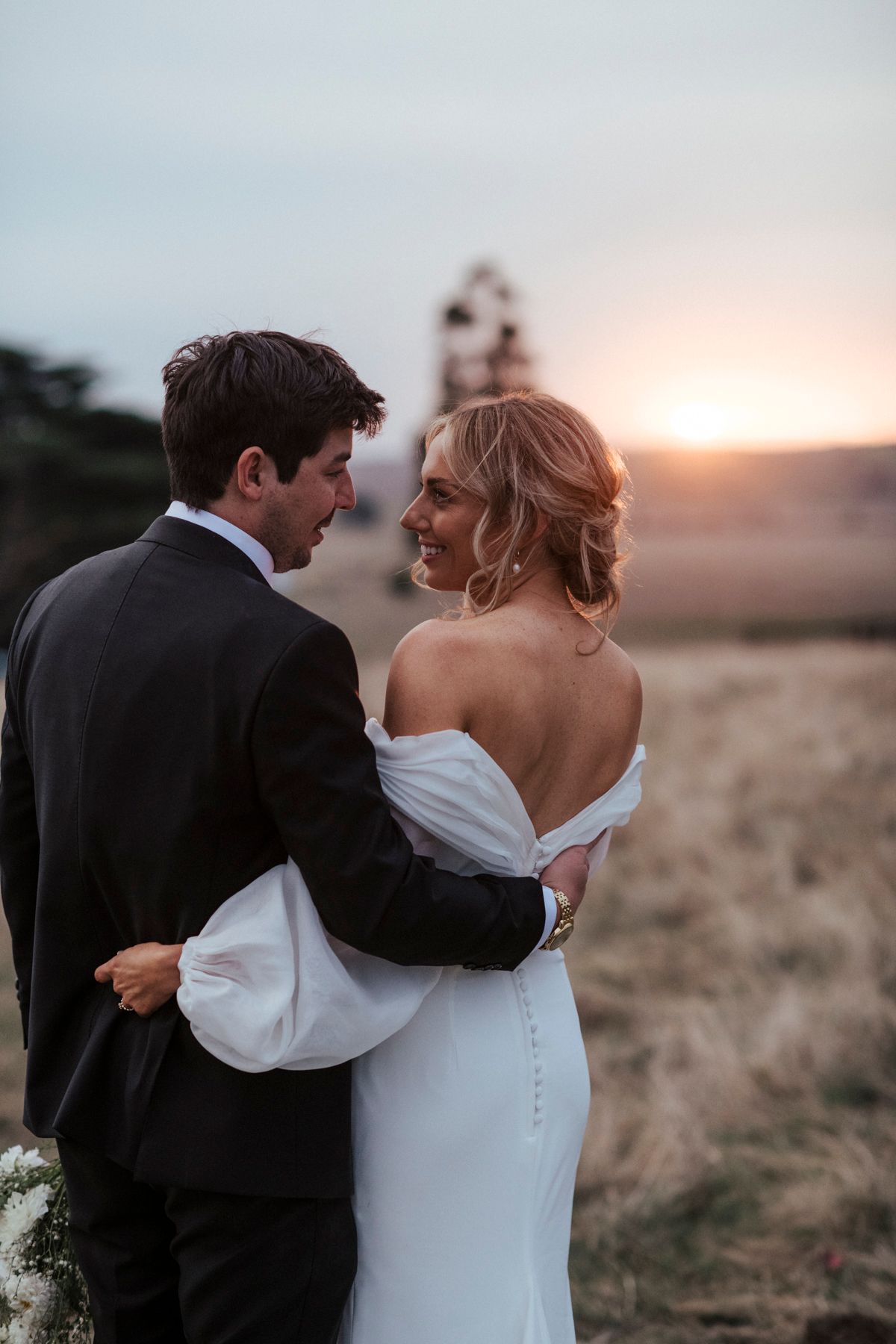 Sunset wedding photography captures romantic moments between couple in formal attire.