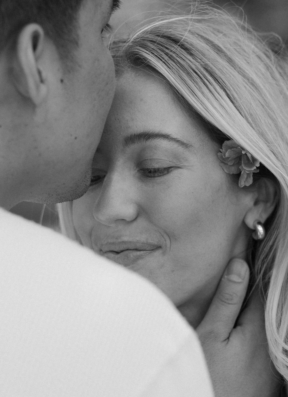Intimate black and white portrait of a couple sharing a tender moment with gentle eye contact and soft expressions.