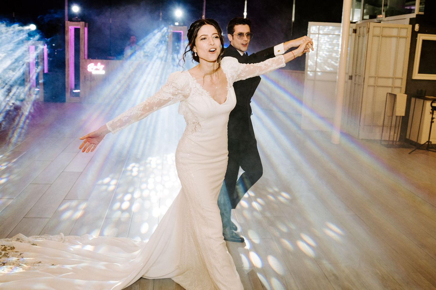 Romantic dance floor moments captured under twinkling lights at an indoor wedding reception.