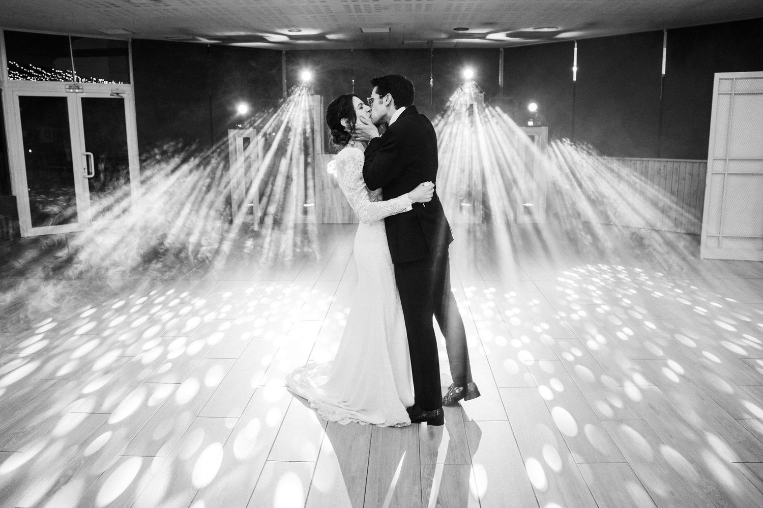 Black and white photo of a couple dancing on a patterned light dance floor.