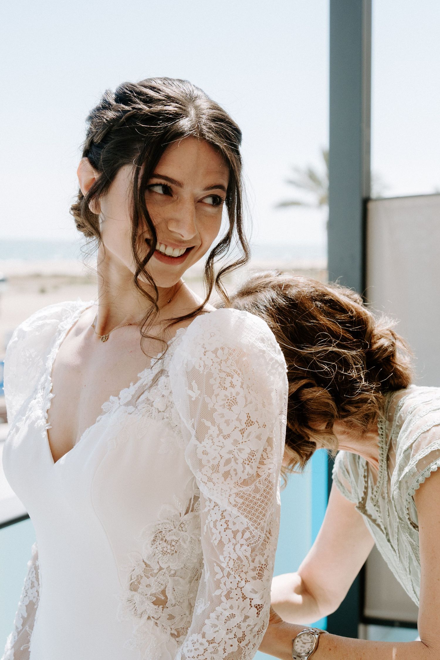 Close-up details of delicate white lace wedding dress with intricate patterns.