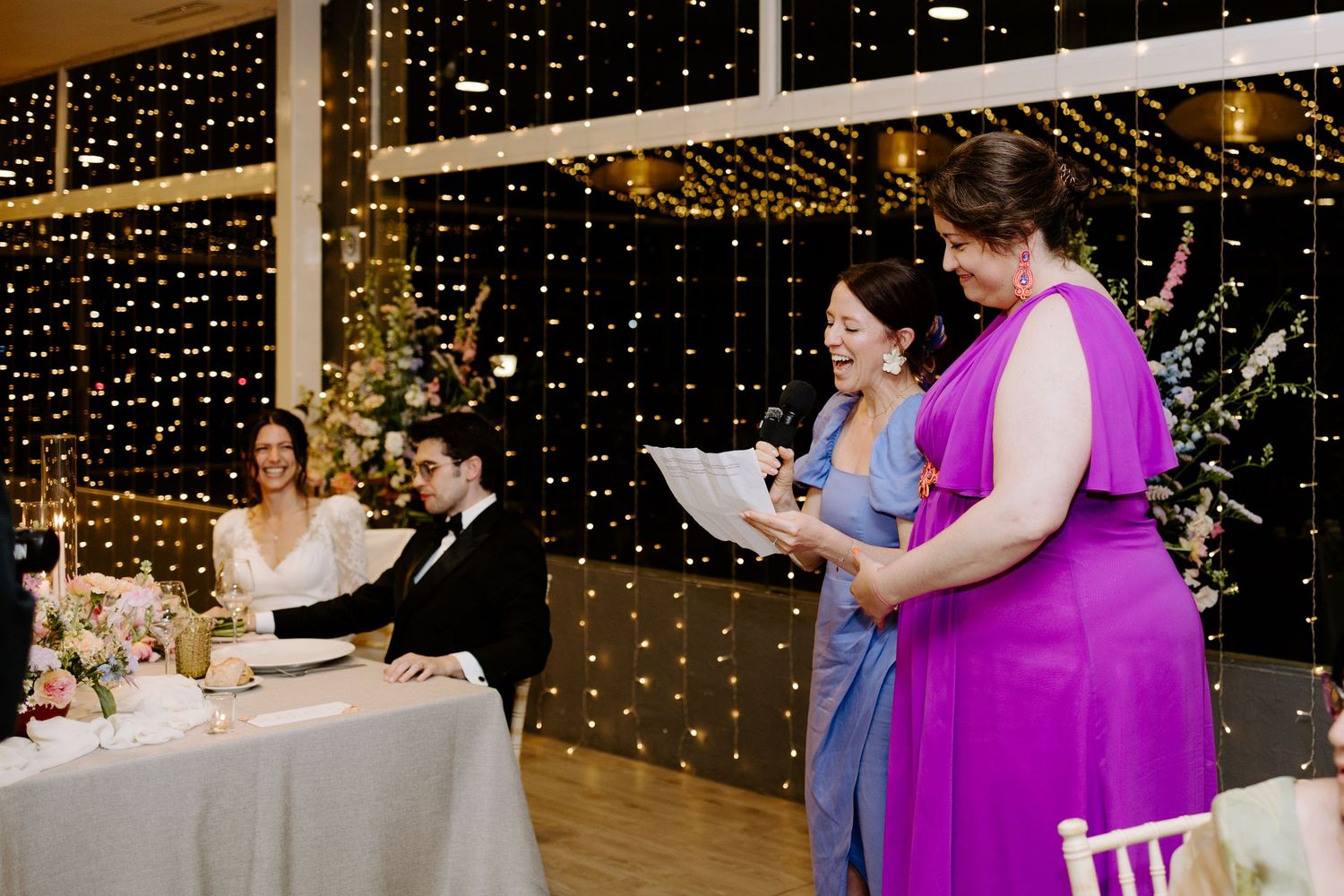 Wedding reception venue decorated with string lights and guests enjoying the celebration.