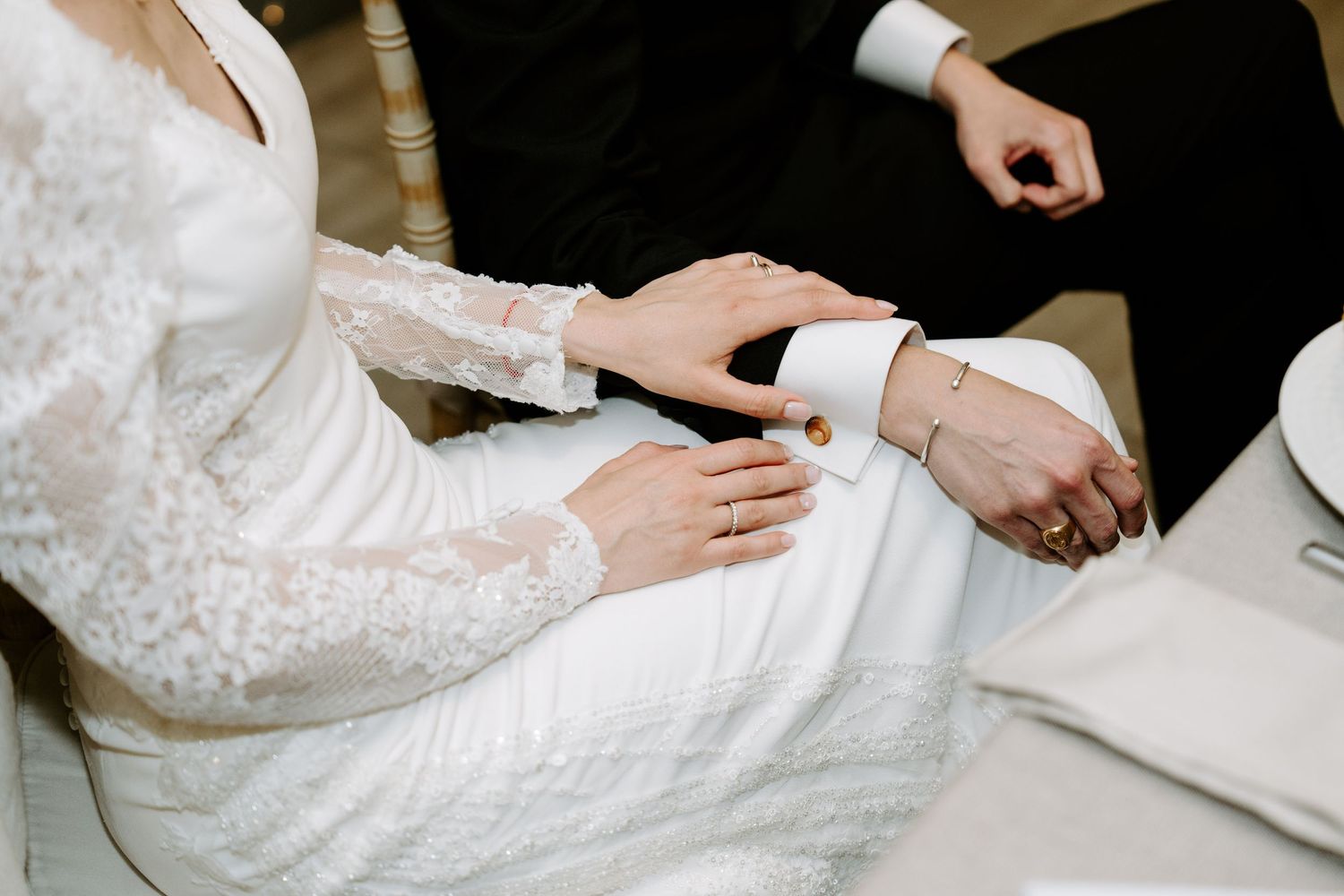 Close-up details of a white lace wedding dress during the reception celebration.