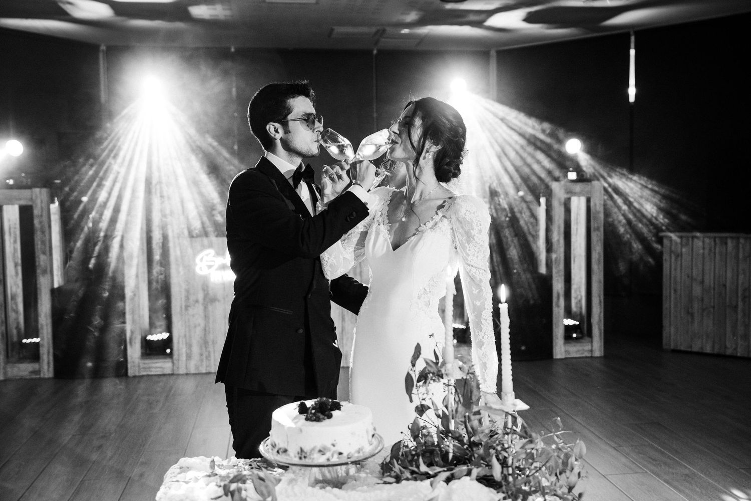 Black and white photo of couple sharing cake during their wedding reception.