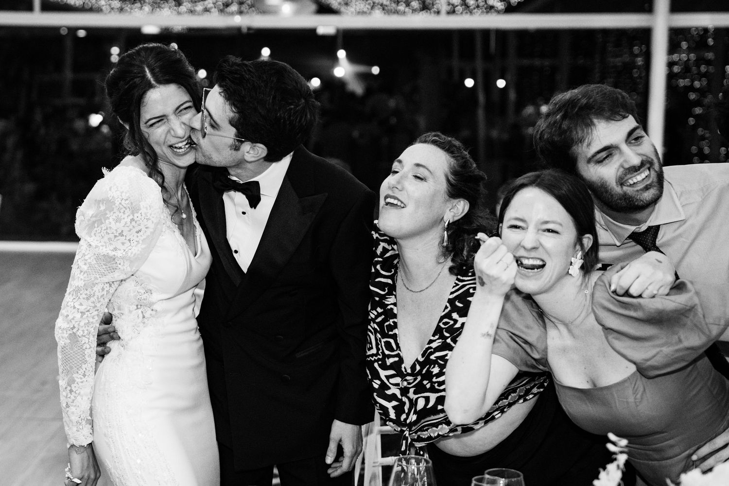 Wedding guests laughing and celebrating during the reception festivities.