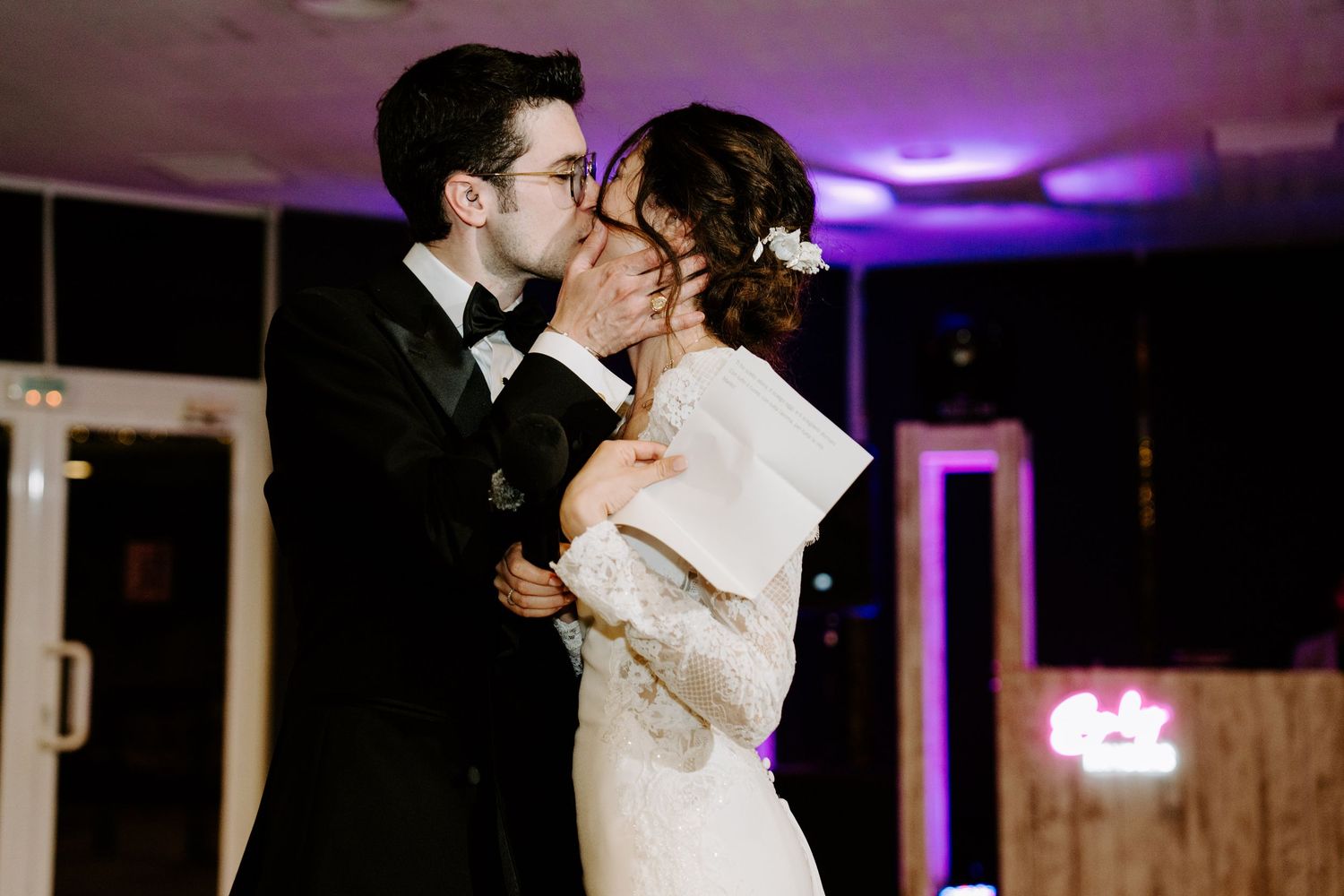 Reception venue illuminated with purple mood lighting and string lights for evening celebrations.