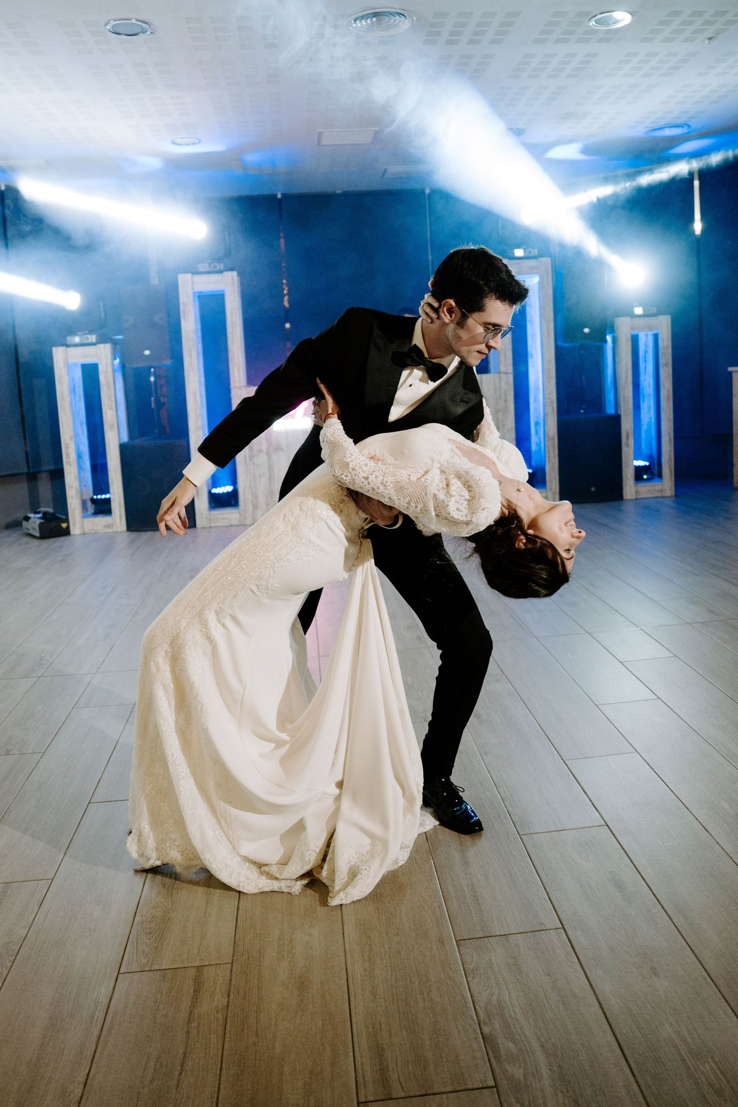 A dramatic dance dip sequence showing flowing white dress movement on a wooden floor.