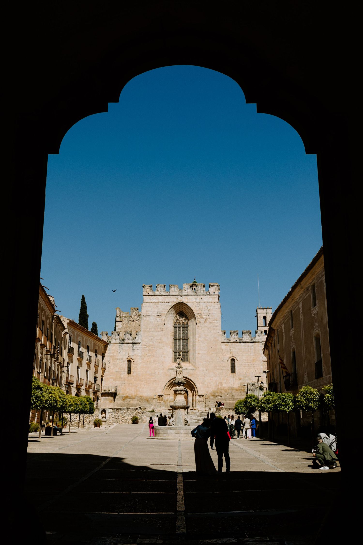 Ancient stone castle courtyard viewed through an arched entrance.