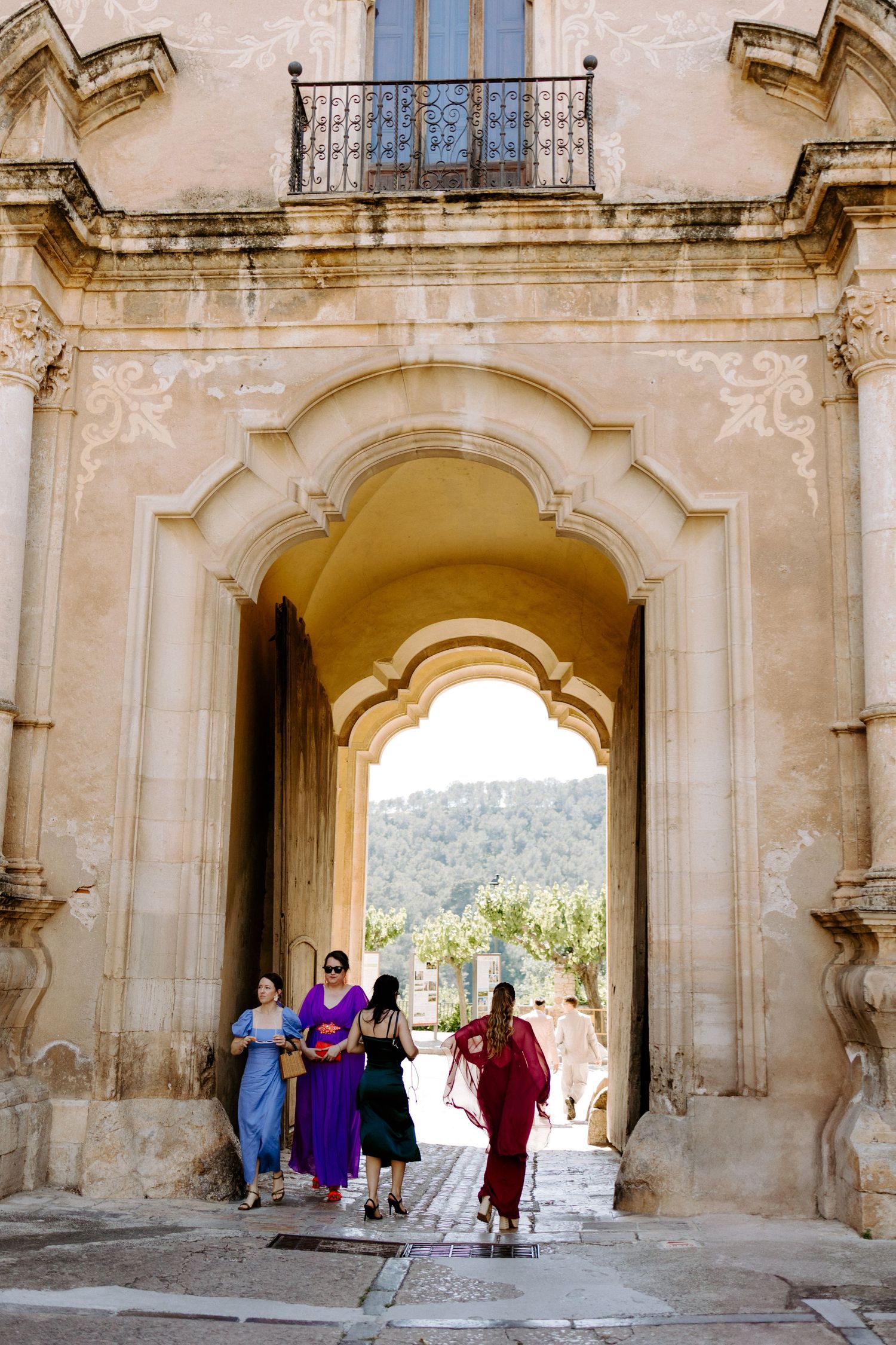 Historic stone archways with visitors walking through the architectural corridor.