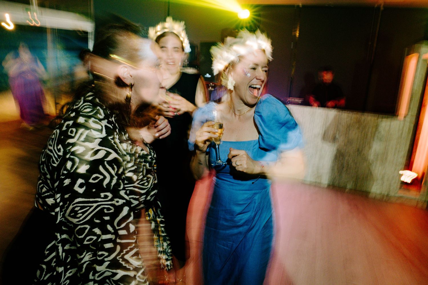 Dynamic party scene with dancers silhouetted against colorful venue lighting.