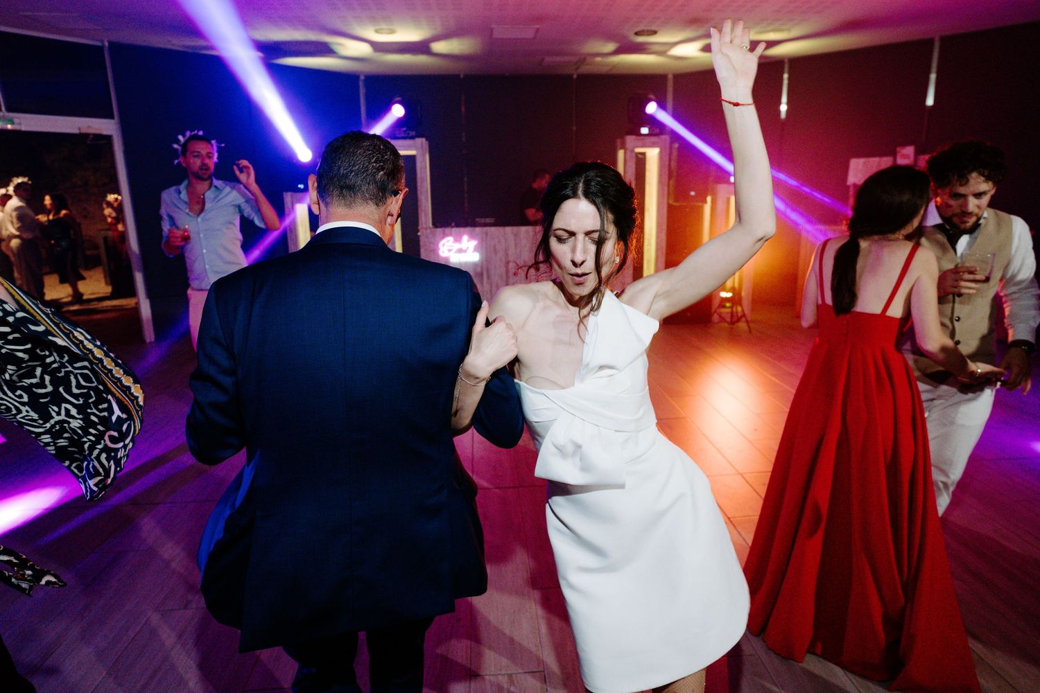 Wedding celebration with purple and blue lighting creating a vibrant dance floor atmosphere.