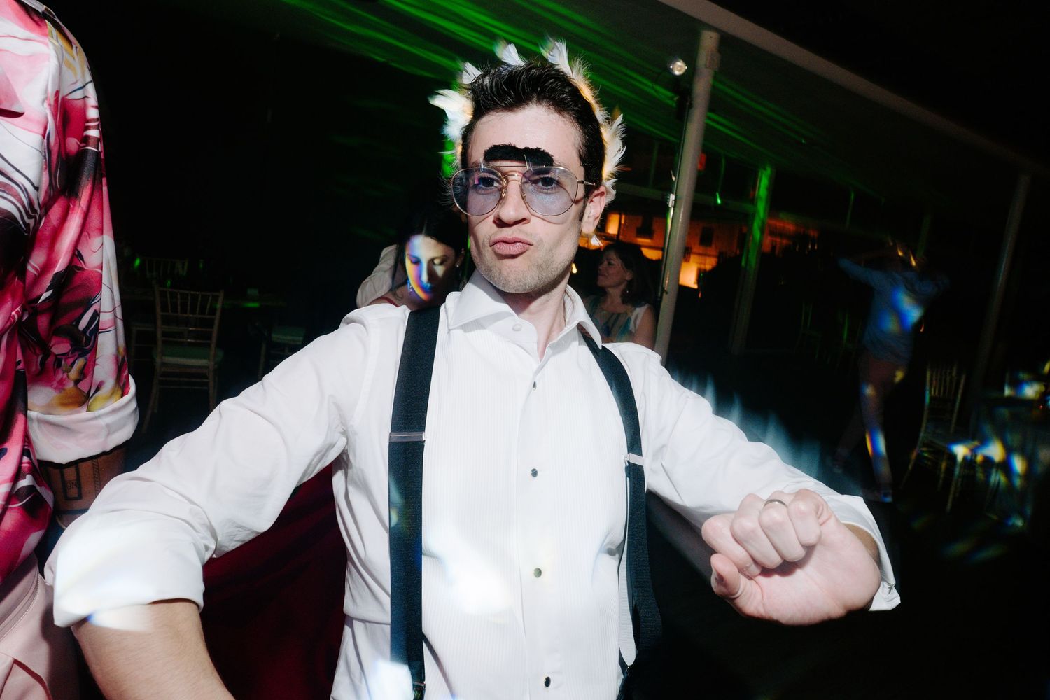 Dynamic dance floor moments captured during a wedding reception with dramatic lighting.