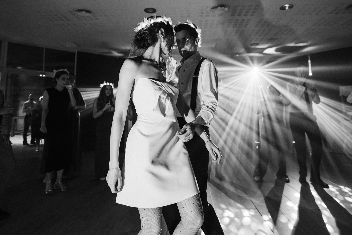 Black and white photos of energetic wedding reception dancing with dramatic lighting effects.
