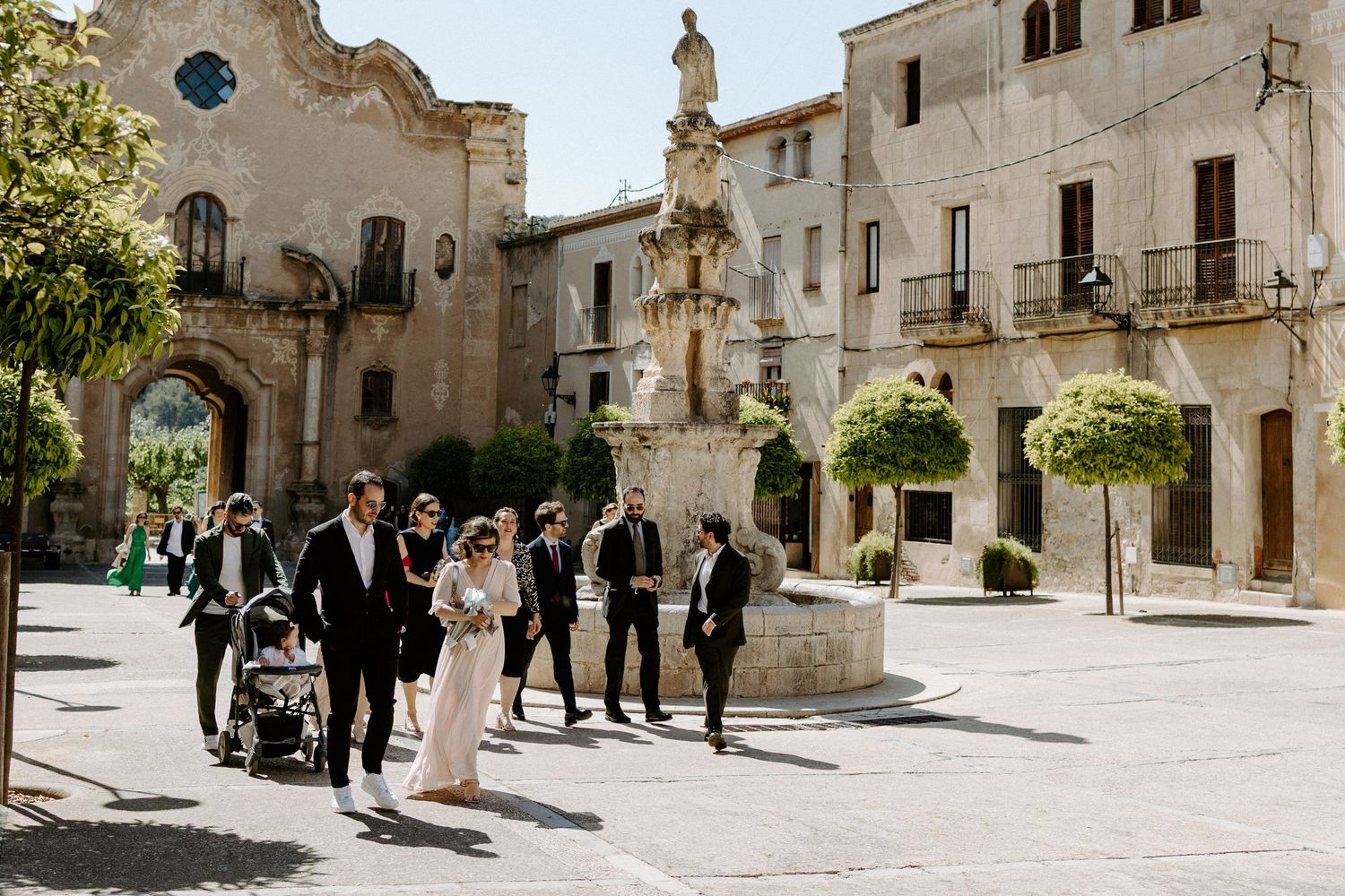 Historic stone plaza surrounded by traditional Mediterranean architecture and visitors.