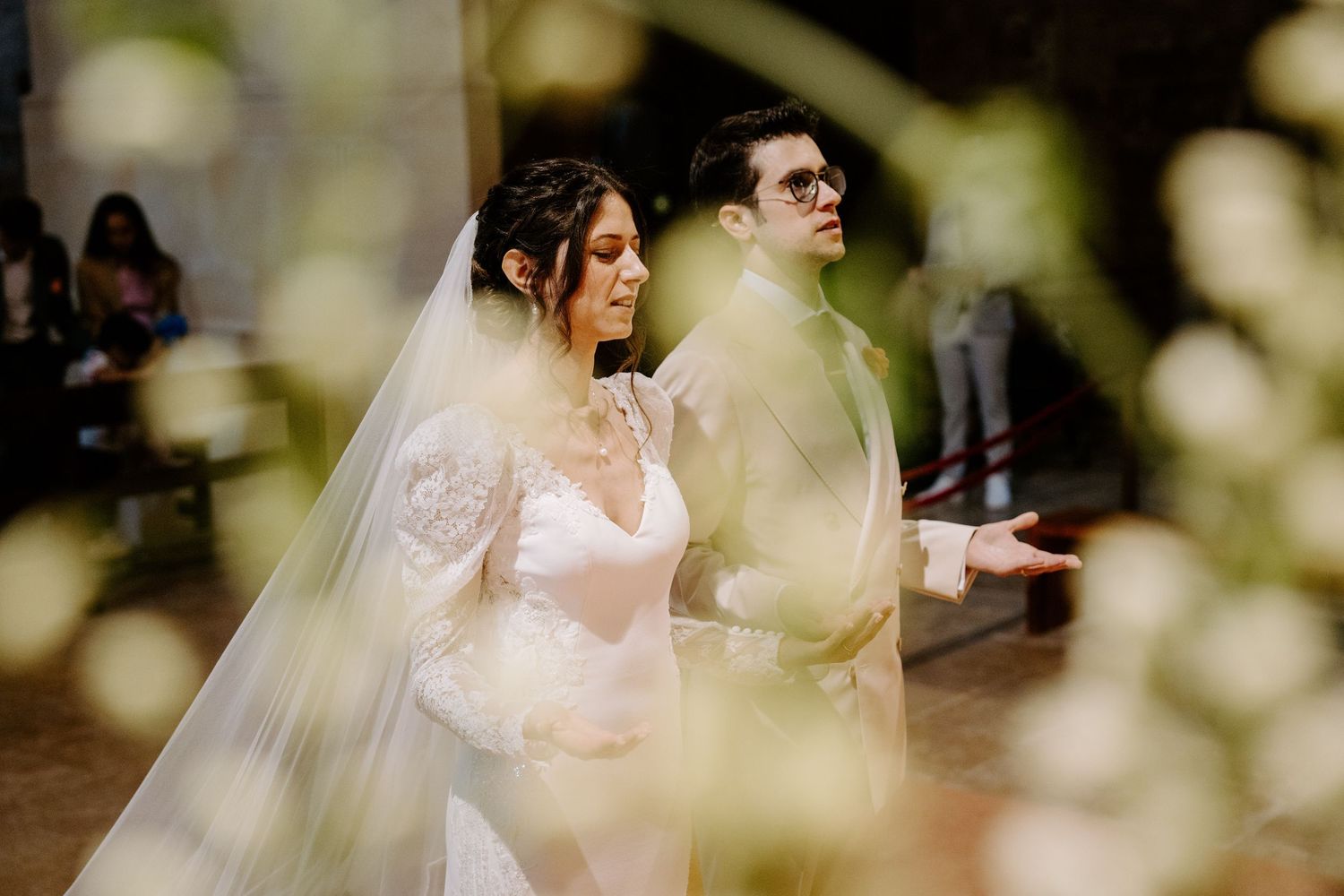 Wedding couple shares an intimate moment in a garden setting with soft bokeh lighting effects.