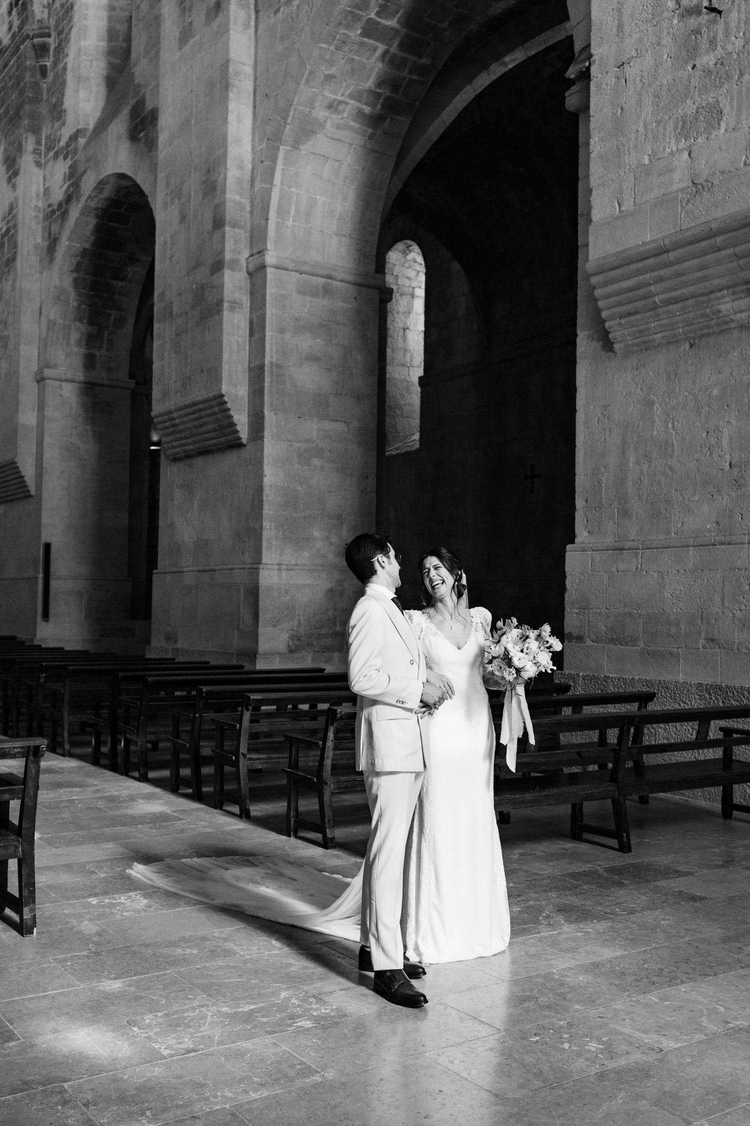 Elegant wedding ceremony inside a historic stone church with dramatic arched architecture.