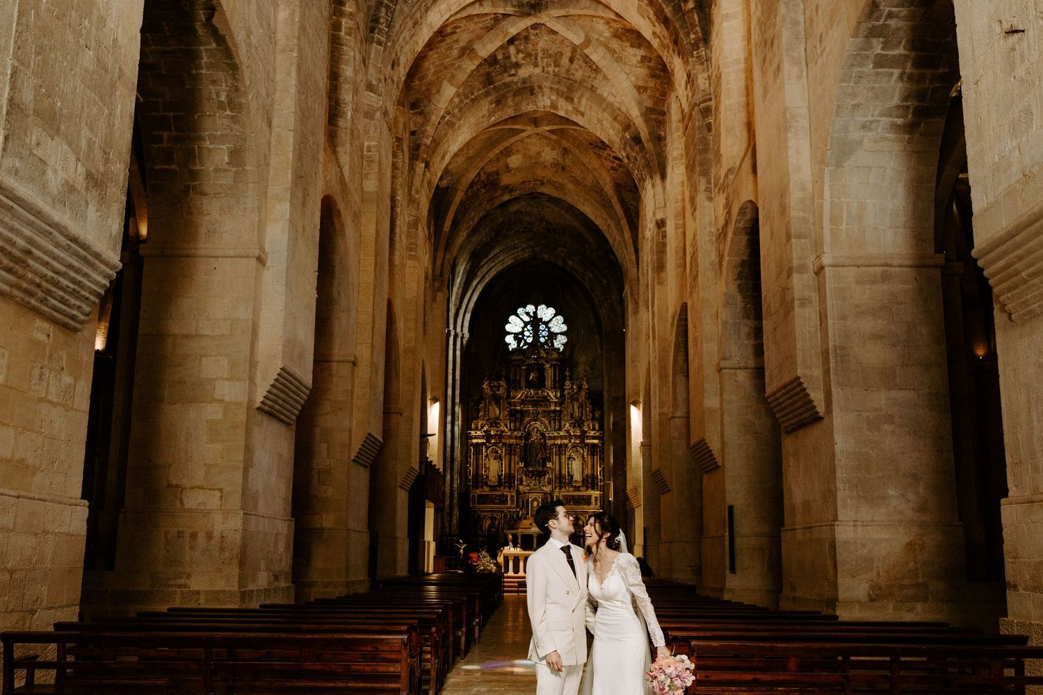 Wedding couple photographed in a stunning cathedral with vaulted ceilings and stone columns.