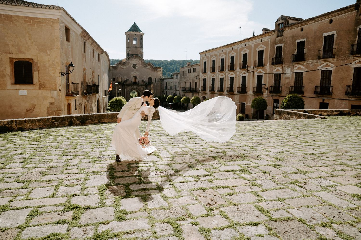 Historic stone courtyard with ancient buildings serving as a dramatic wedding photo backdrop.