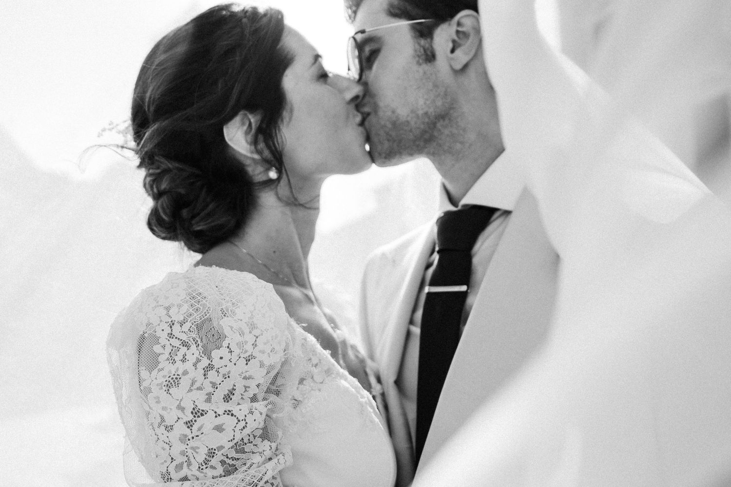An intimate black and white portrait of newlyweds sharing a tender moment.