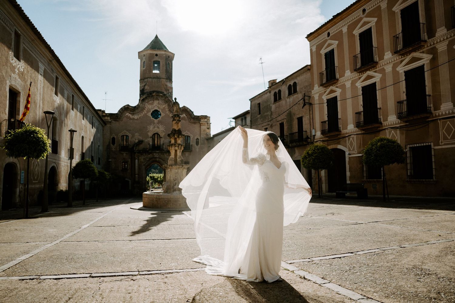 A panoramic view of a bride dancing in a historic Italian town square.