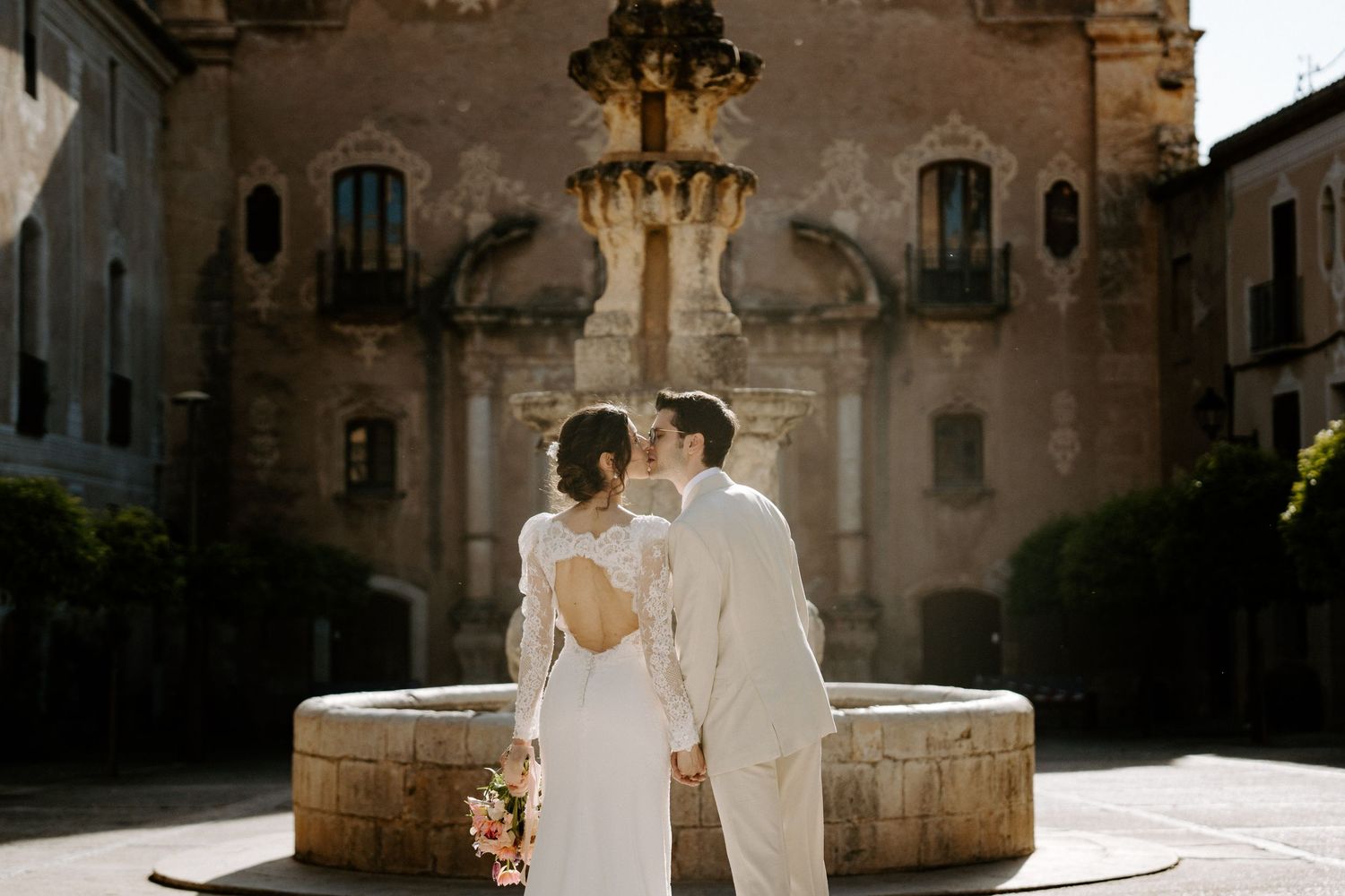 A wedding couple shares an intimate moment in front of a historic Italian church.