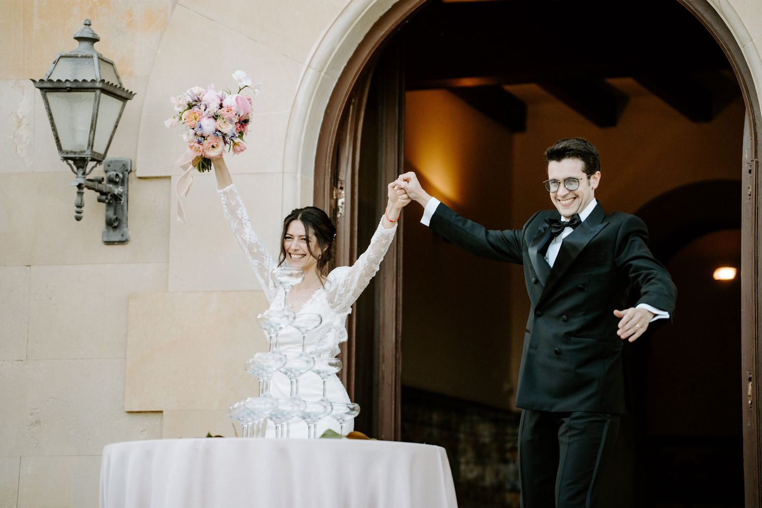 Wedding celebration setup with elegant cake display under stone archway.