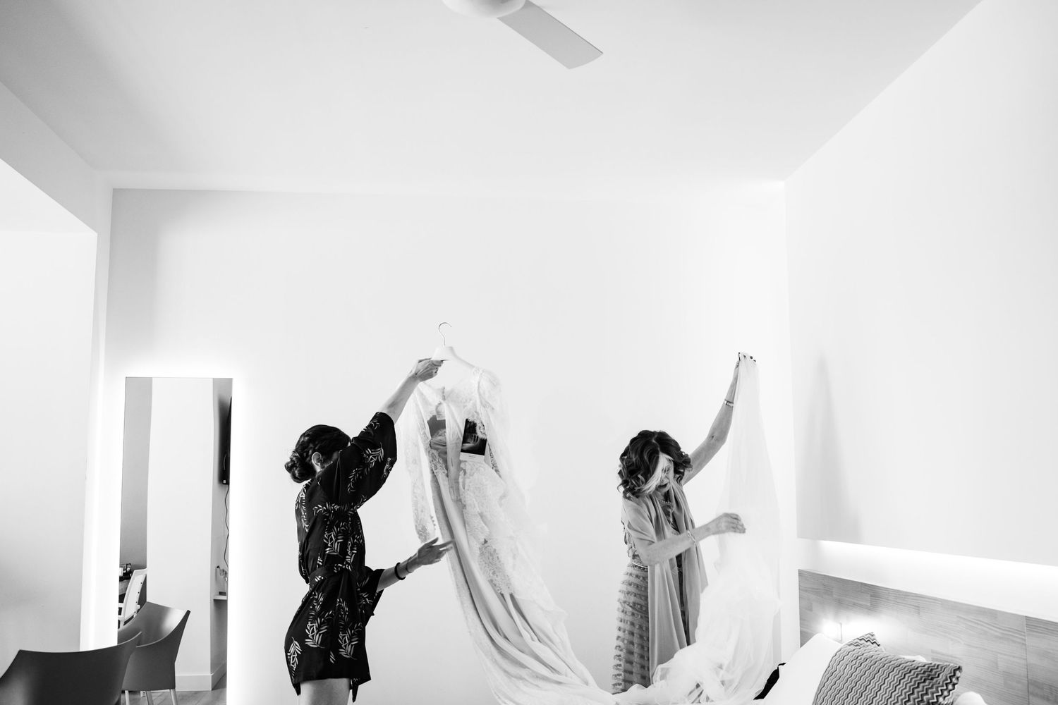 Dance performers in white outfits creating dynamic movements against a bright background.