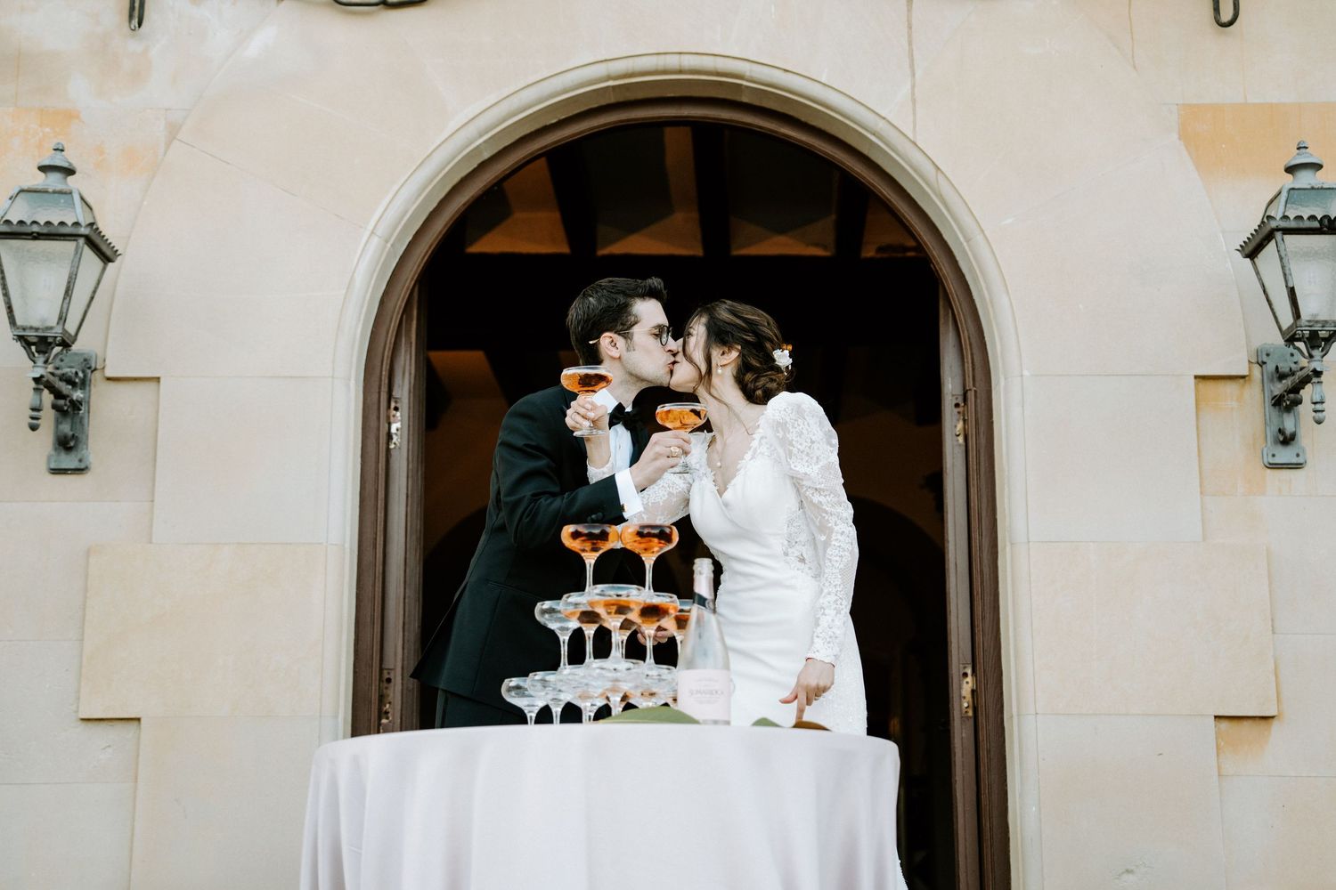 Champagne cascades down a tower of glasses during an elegant wedding celebration.
