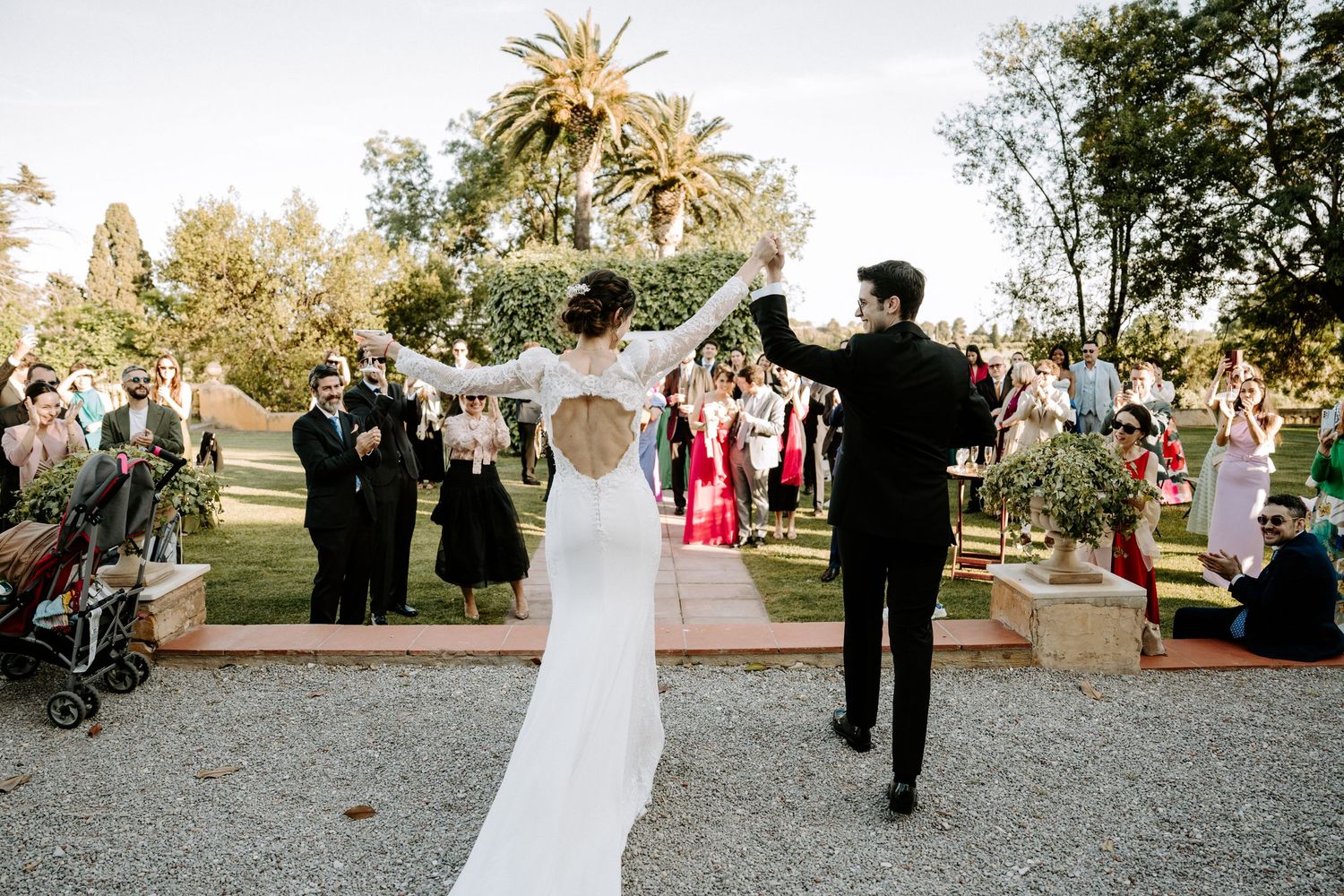 Wedding celebration at a Mediterranean villa with palm trees and stone architecture.