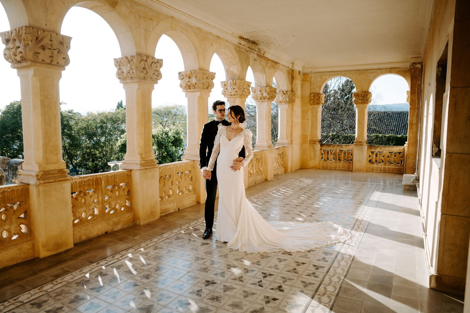 Panoramic view of a romantic wedding photoshoot in a grand architectural colonnade.
