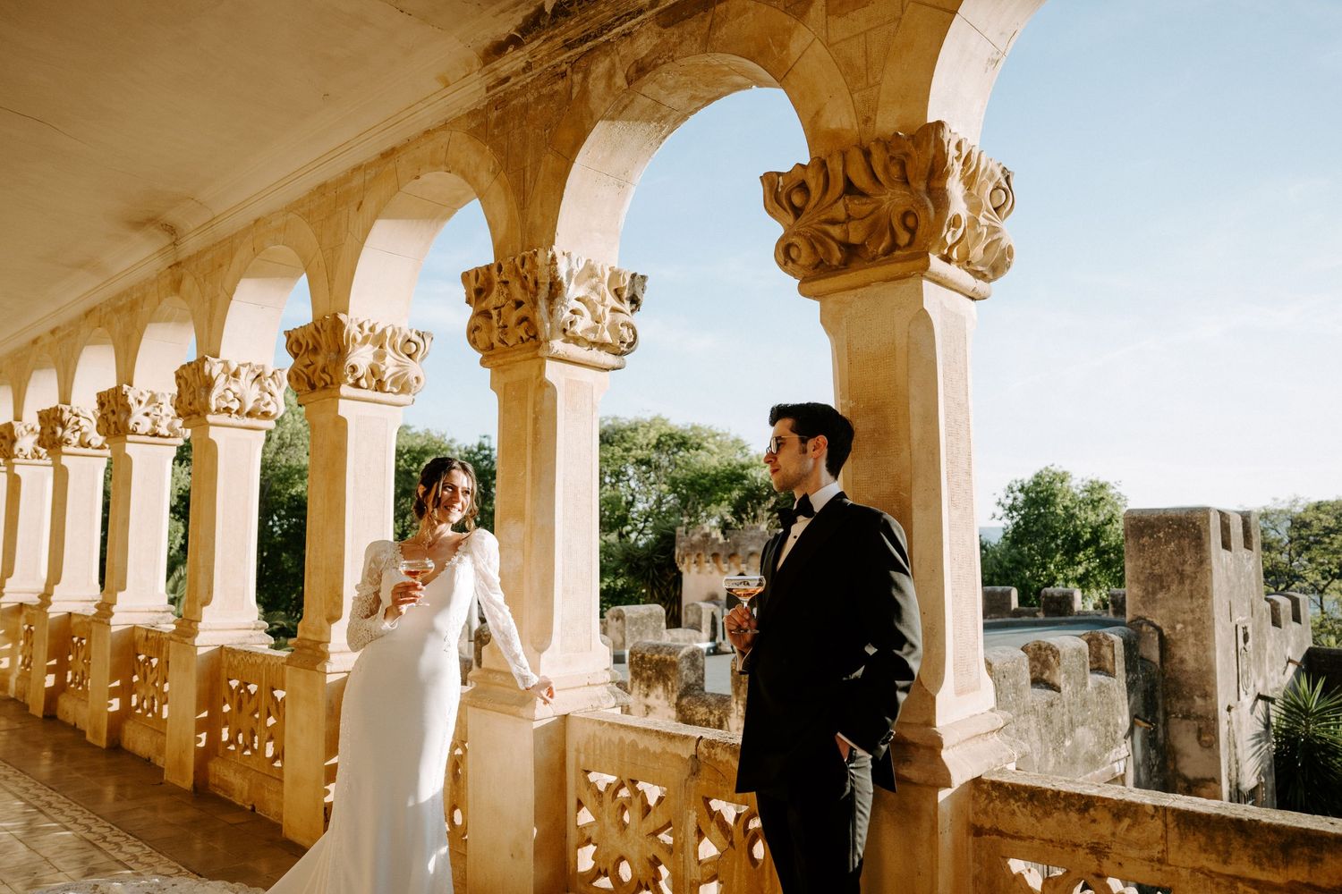 Elegant colonnade with decorative stone details frames wedding photography session.