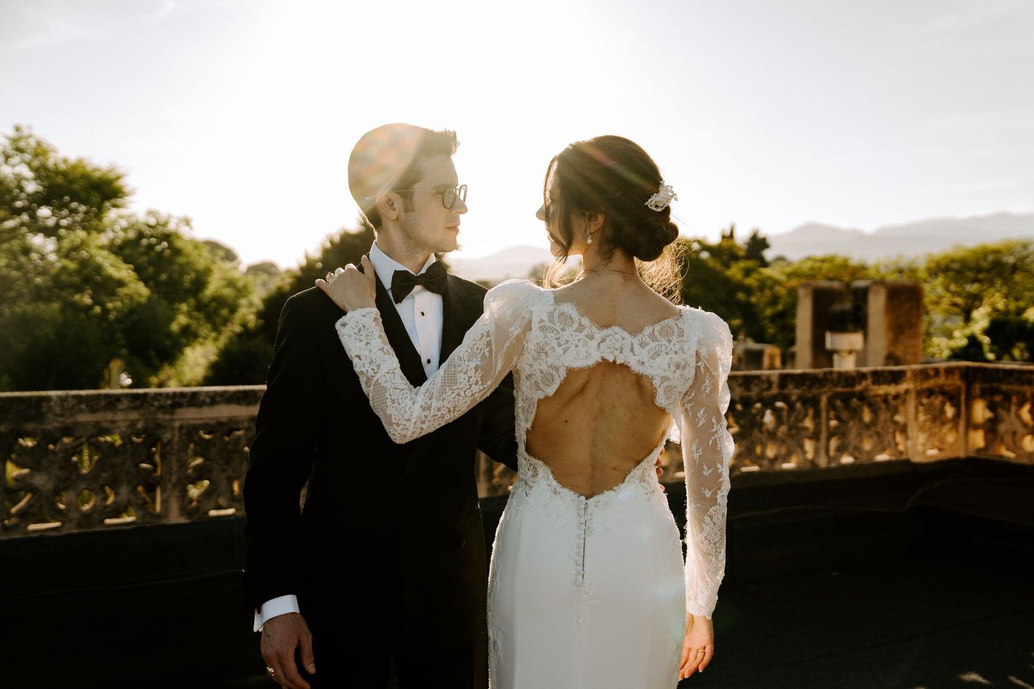 Golden hour wedding portraits captured in elegant architectural setting.