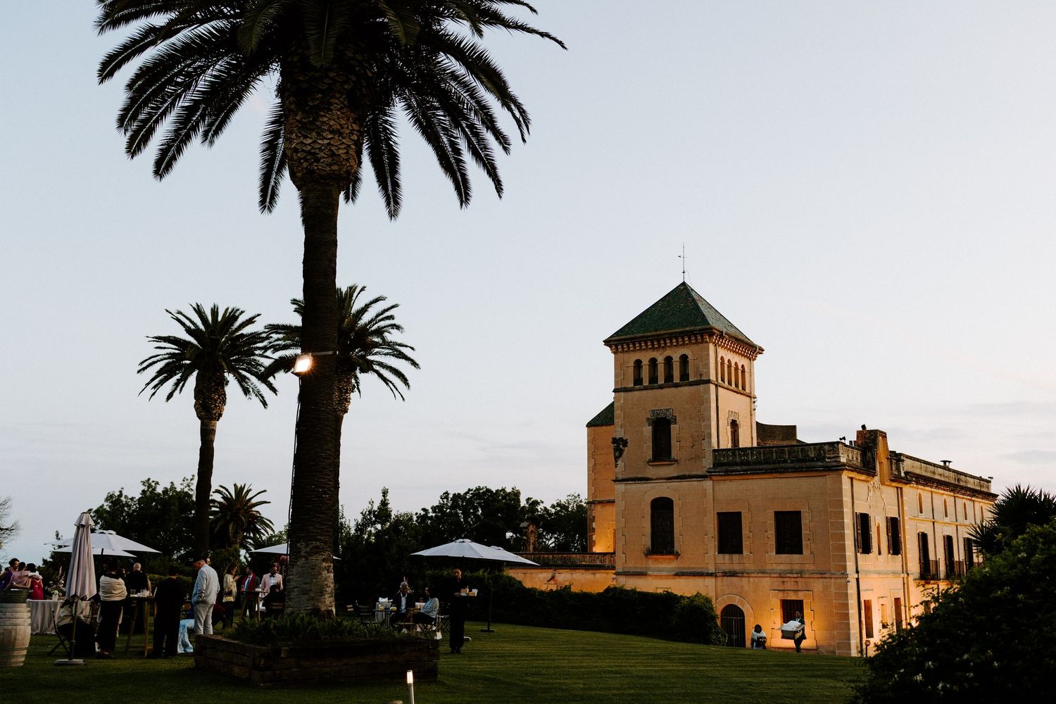 Spanish colonial style buildings and palm trees create a romantic wedding venue silhouette at sunset.