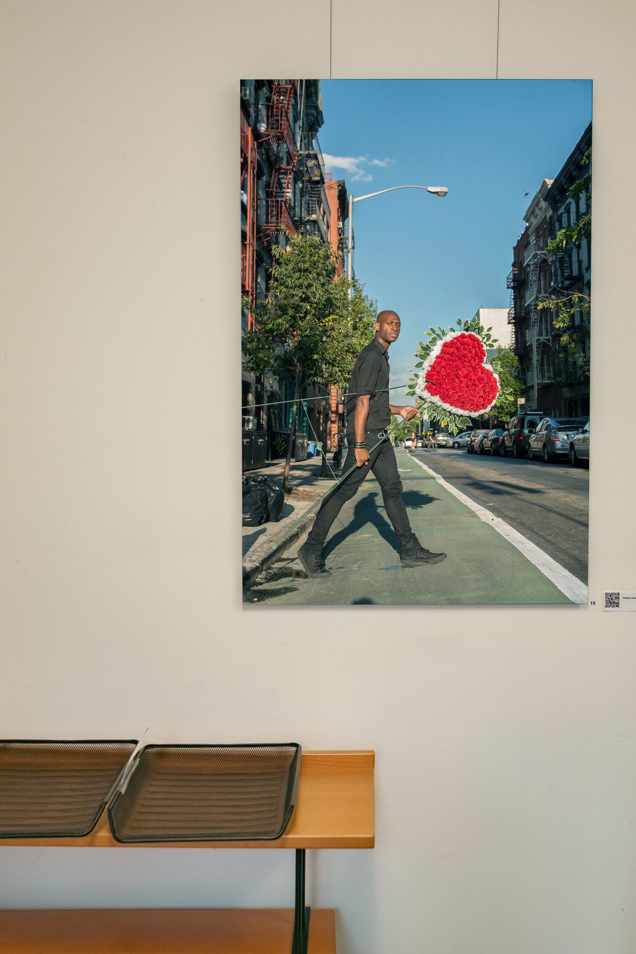 Modern office lobby with red chairs and framed artwork on white walls.