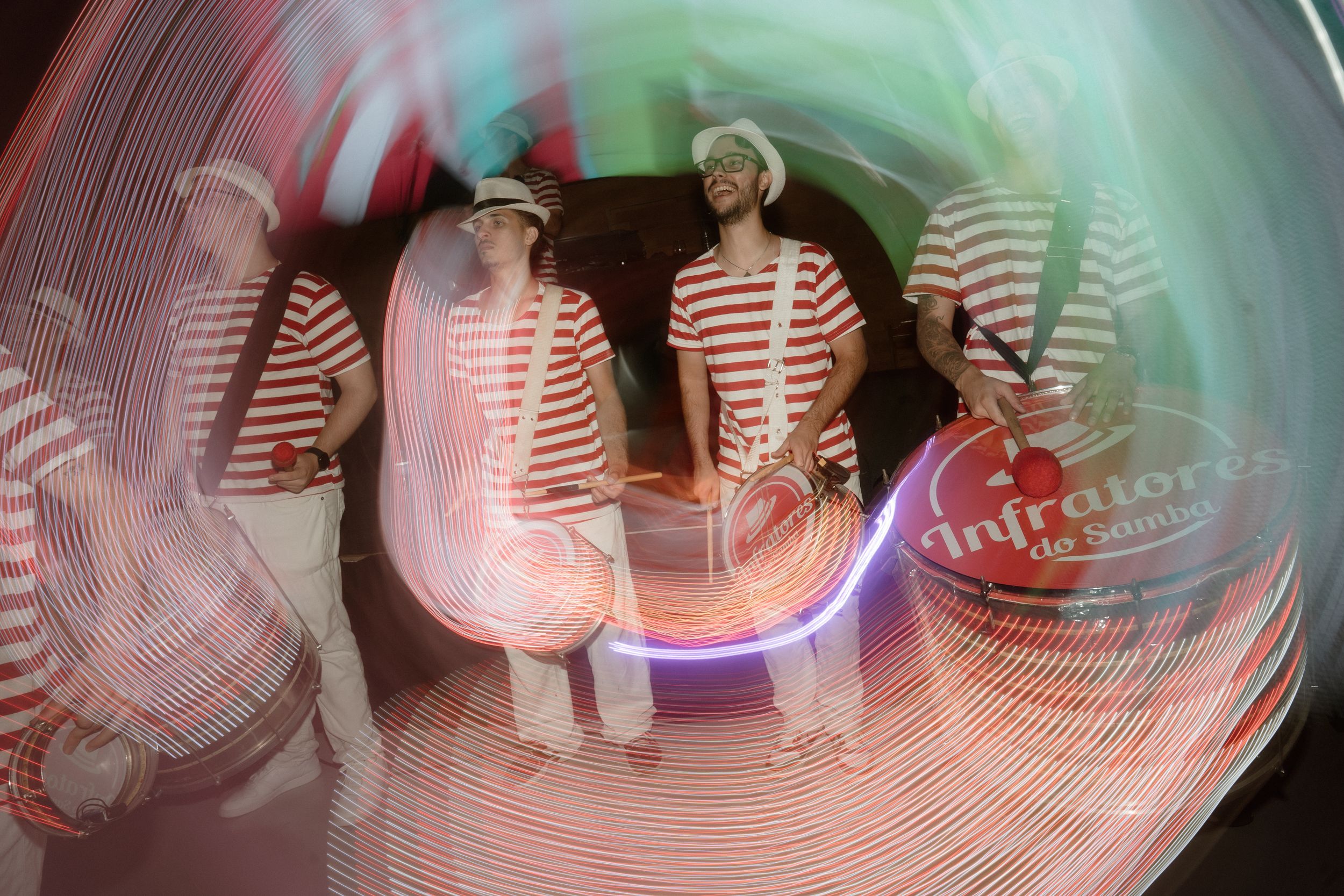 Blurred motion capture of dancers in striped shirts under theatrical lighting.