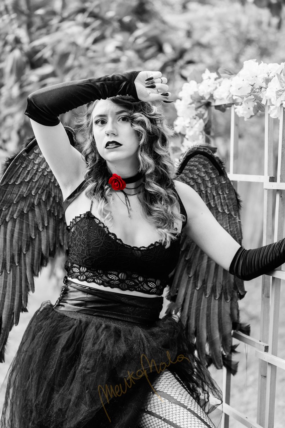 Gothic fantasy portrait with black wings and red accent in black and white style.