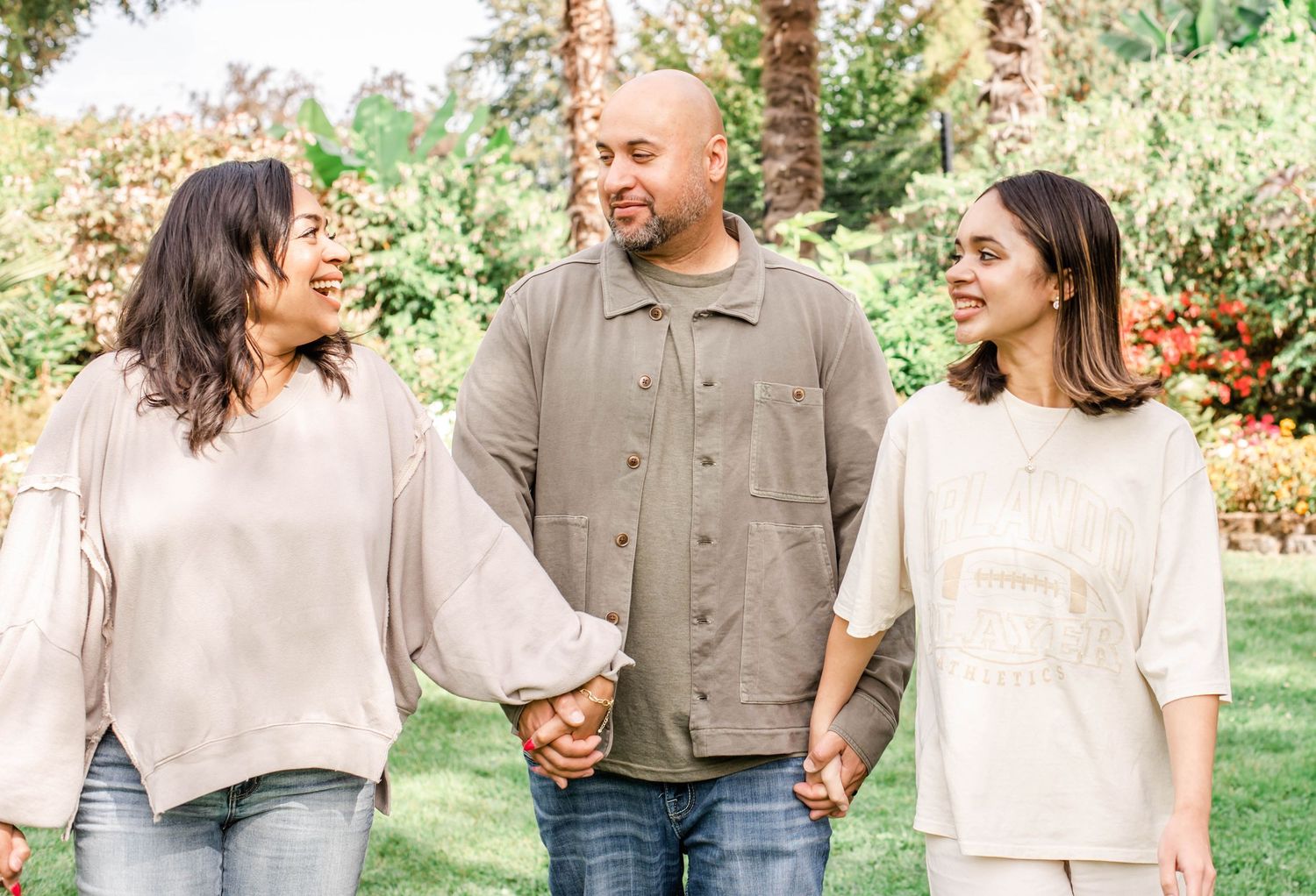 Candid group photo of people walking and laughing on grass with palm trees.