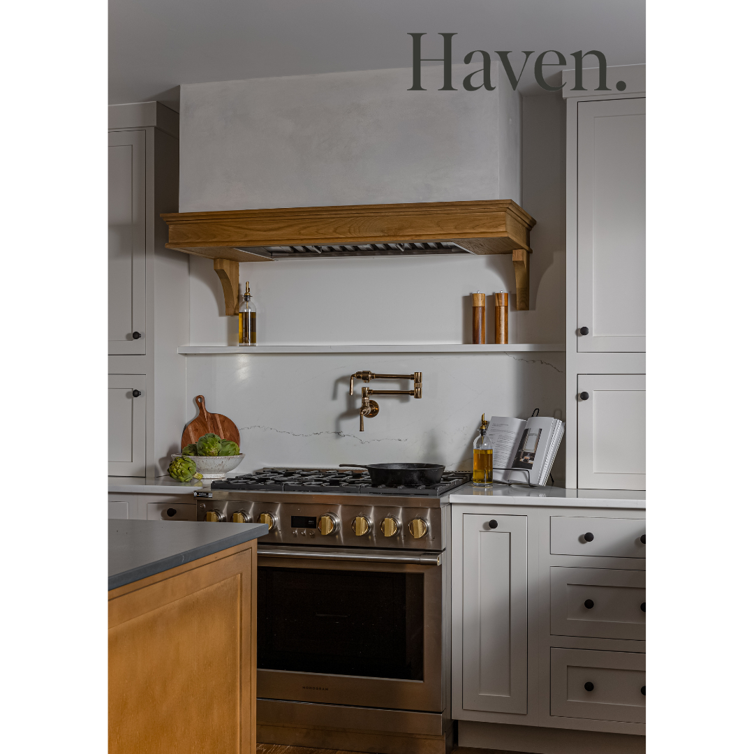 Heather Ison Photography for Haven. Modern white kitchen with wooden range hood and pot filler faucet above professional gas stove.