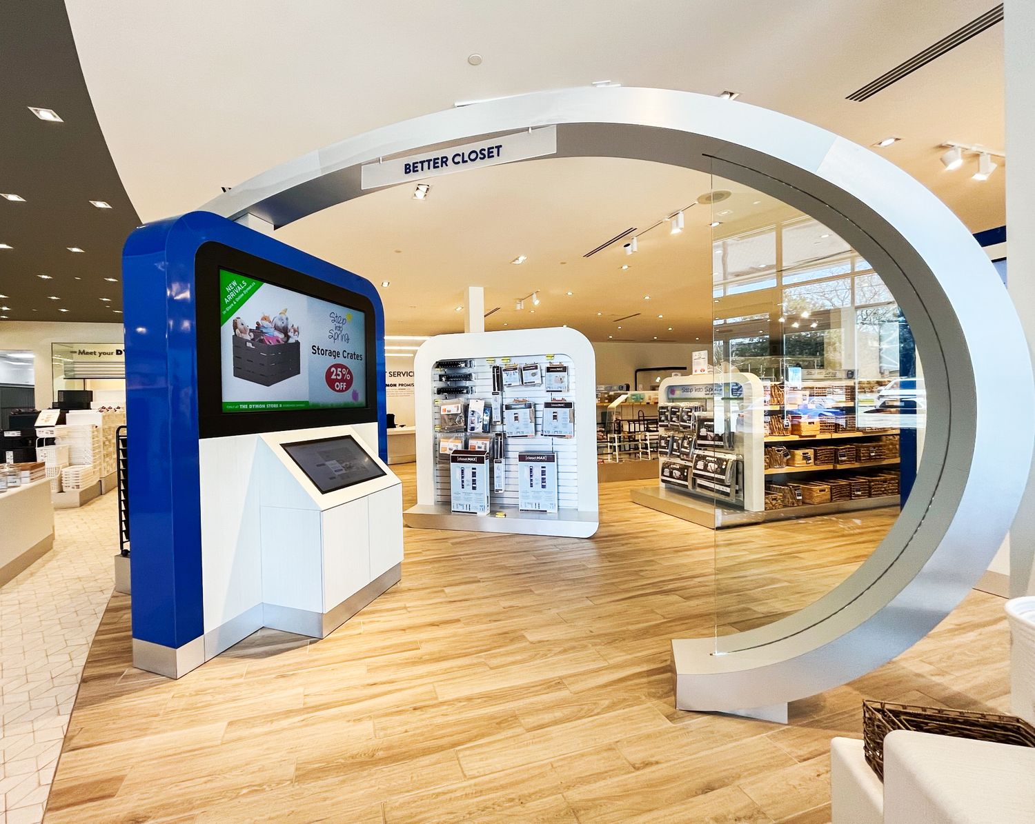 Modern retail display with curved arch entrance featuring digital screens and kiosks in a bright store interior.