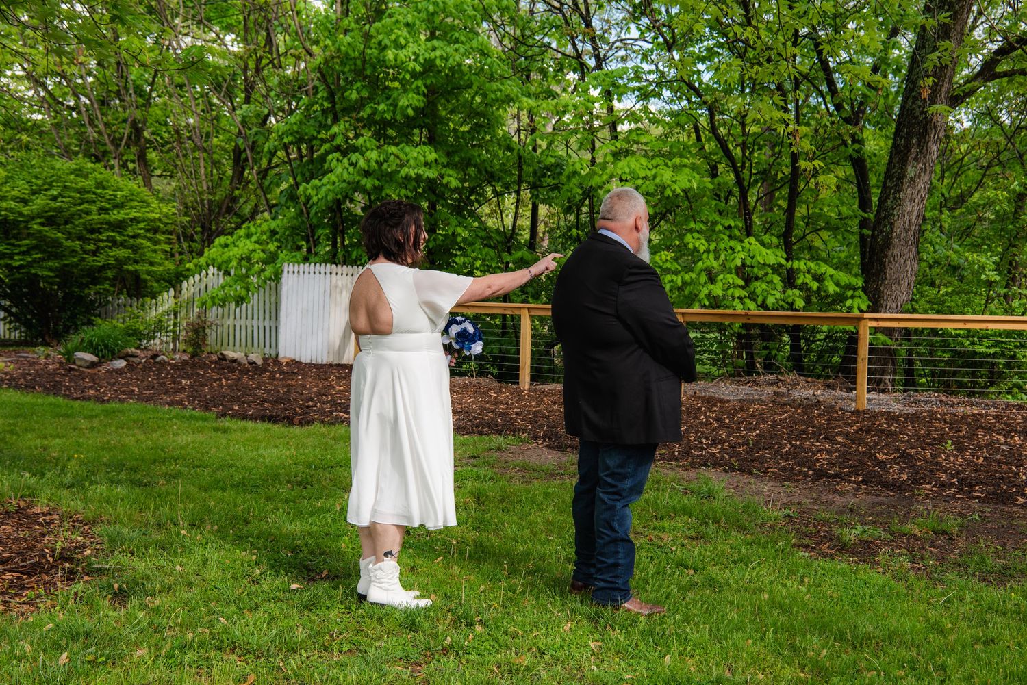 Intimate outdoor wedding ceremony taking place in a peaceful garden setting.
