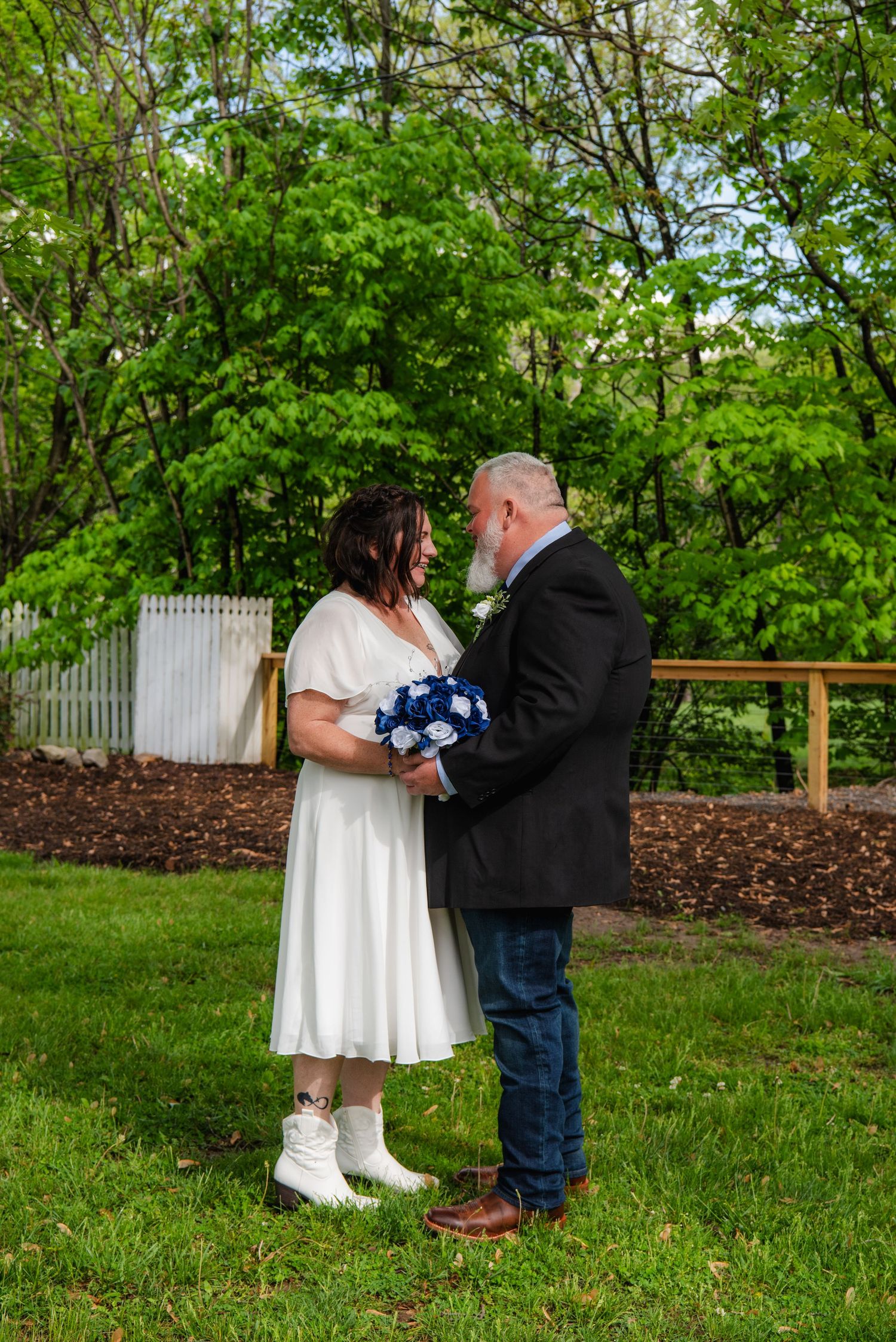 Couple sharing intimate moment during outdoor wedding ceremony in spring garden setting.
