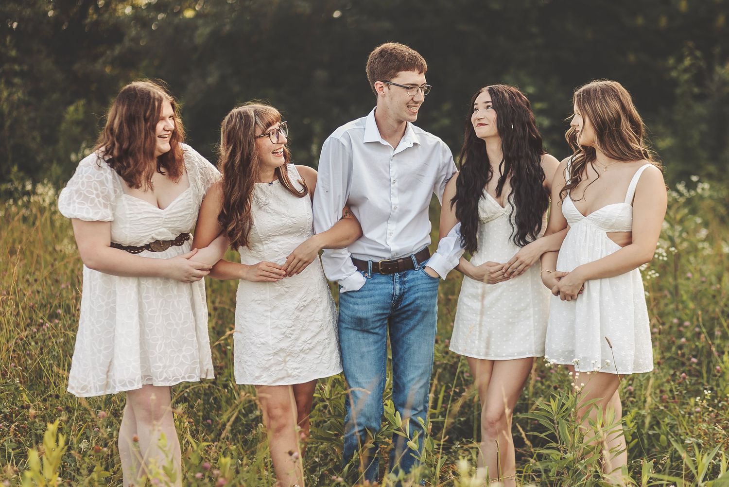 Copyright - Rose Lee Photography - Group of four women in formal dresses posing outdoors with flowers at an event.