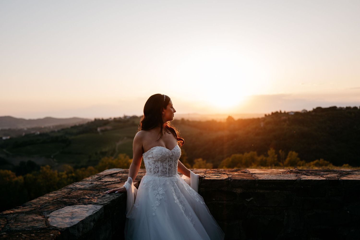 Newlyweds celebrating with guests during an outdoor ceremony under a stone archway.
