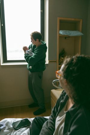 A sequence of photos showing someone stretching and yawning while sitting near a bright window.