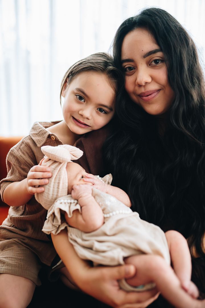 Mother cradling her newborn with her son during a newborn photoshoot at home by Melbourne newborn and family photographer Pei A Photography