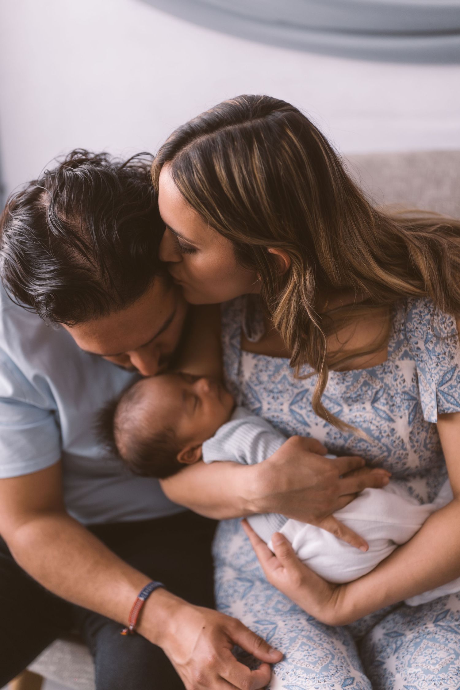 Intimate family moment shared on couch with newborn baby.
