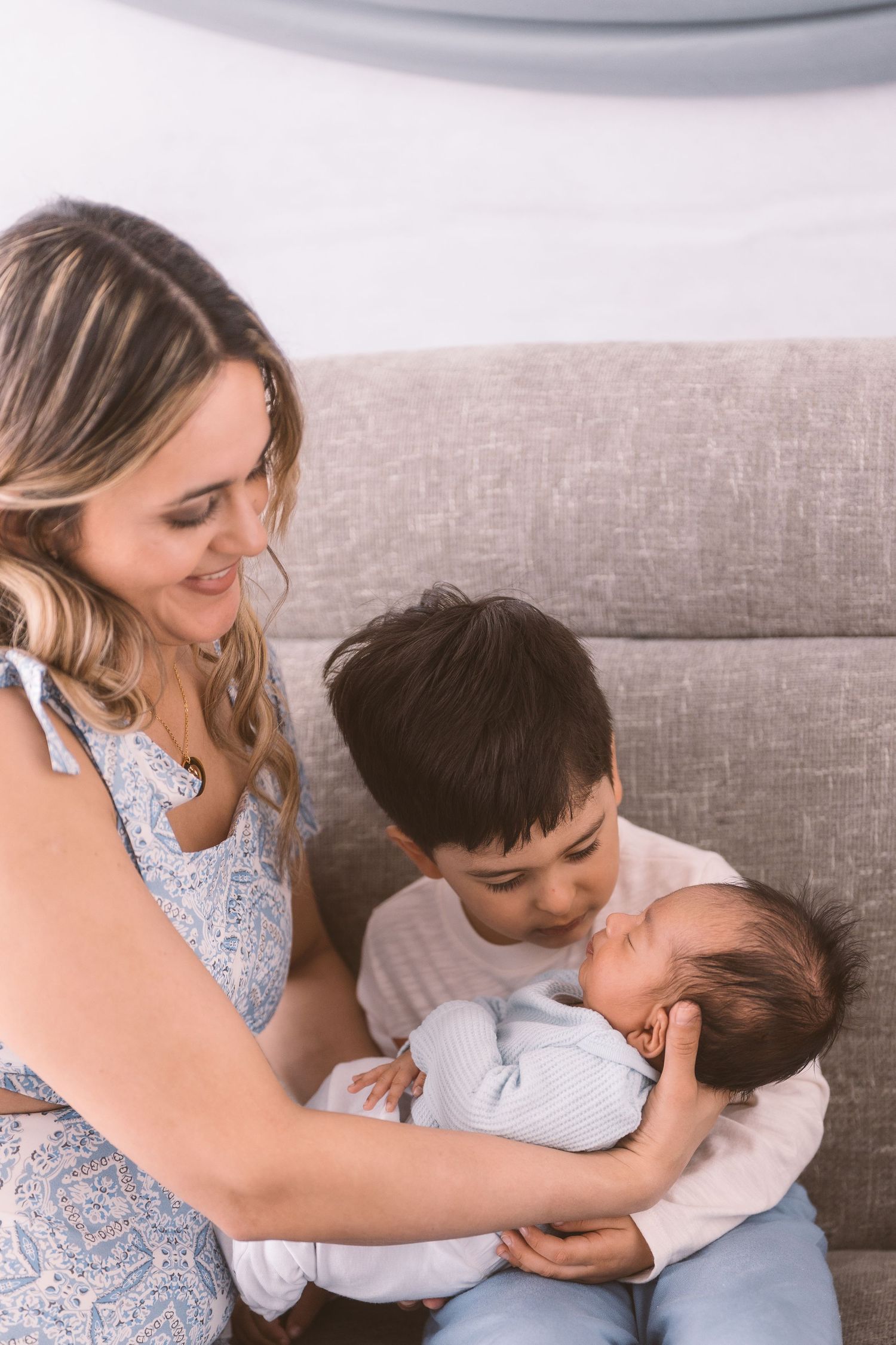 Family sharing tender moment together on gray couch.